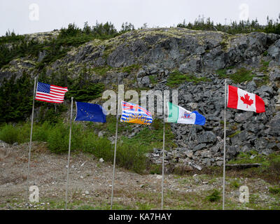 Les drapeaux de nous / frontière canadienne au sommet du col White, White Pass & Yukon Railroad entre Skagway, Alaska et Whitehorse, Territoire du Yukon, Canada. Banque D'Images