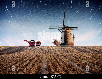 Nuit de printemps colorés avec des moulins à vent traditionnel néerlandais à rotterdam. canal jetée en bois près de la rive du lac. holland. aux Pays-Bas. superbe ciel étoilé et la voie lactée Banque D'Images