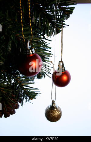 Rouge et Or de noël baubles hanging on christmas tree Banque D'Images