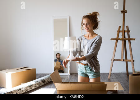 Jeune couple déménagement en nouvelle maison, déballage des boîtes. Banque D'Images