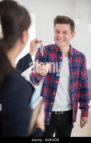 Récupérez les clés à l'homme nouvelle maison de female realtor Banque D'Images