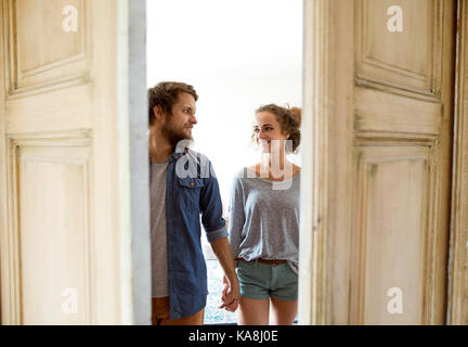 Couple moving in new house, qui entre par la porte. Banque D'Images