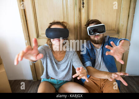 Jeune couple avec lunettes vr déménagement dans maison neuve. Banque D'Images