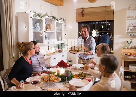 Célébrer Noël en famille. père apportant de la nourriture. Banque D'Images