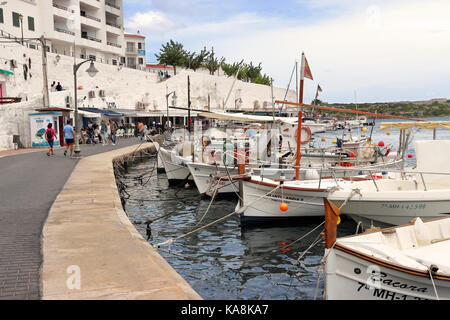 Es Castell en Minorque avec les bateaux de pêche et yachts amarrés sur le quai et au-dessus des nuages orageux Banque D'Images