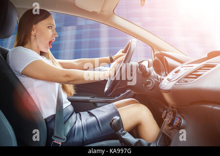 Jeune femme pilote effrayé freins crissement éviter un accident. choqué girl tooting corne Banque D'Images