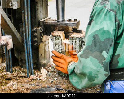 Bois de chauffage à hacher travailleur avec une machine close up Banque D'Images
