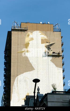 Une gigantesque fresque de Leonard Cohen d'être peinte sur le côté d'un immeuble sur la rue Crescent au centre-ville de Montréal, Québec, Canada Banque D'Images