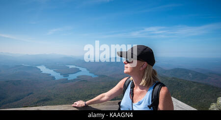 Femme à l'aide à la recherche de la vue depuis le sommet du mont Whiteface à Lake Placid dans l'arrière-plan Banque D'Images