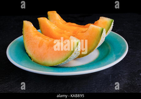 Melon cantaloup juteux frais sur un fond noir. Banque D'Images