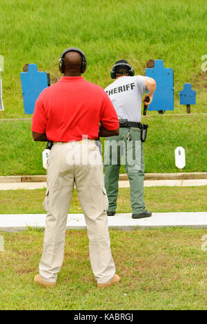 Instructeur en armes à feu supervise un agent d'application de la loi sur le champ de tir d'un centre de formation aux États-Unis. Banque D'Images