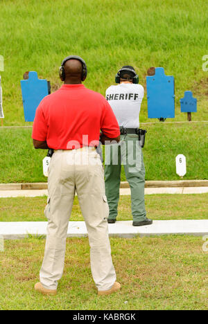 Instructeur en armes à feu supervise un agent d'application de la loi sur le champ de tir d'un centre de formation aux États-Unis. Banque D'Images