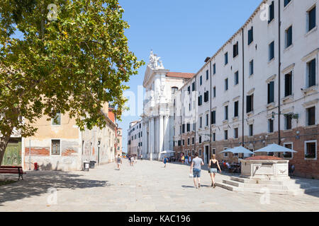 Vue sur le Campo dei Gesuiti, Cannaregio, Venise, Italie, avec quelques touristes à marcher en direction de l'Église et le lagon Gesuiti avec l'ancien puits et le gre Banque D'Images