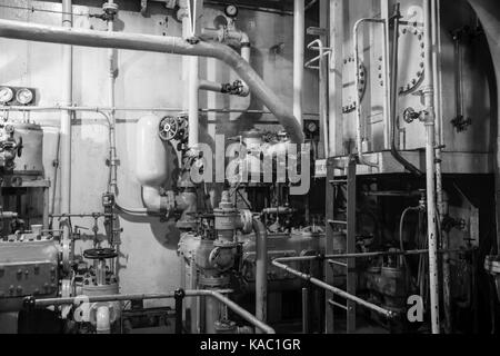 Robinets et tuyaux dans la salle des machines à vapeur d'époque de la DEUXIÈME GUERRE MONDIALE Liberty Ship en noir et blanc.. Banque D'Images