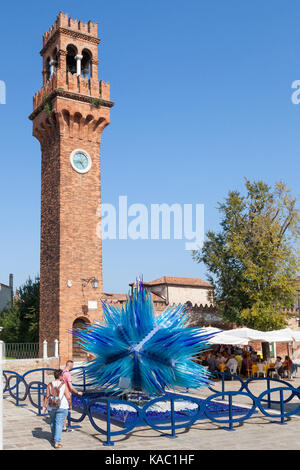 Deux touristes admirant le bleu Comète Étoile de verre au pied de la tour de l'horloge à Campo Santo Stephano, par Simone Cenedese, Murano, Venise, Italie, un p Banque D'Images