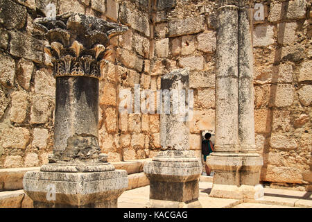 Femme va dans la porte du mur de basalte dans les anciennes ruines de Capharnaüm en Israël Banque D'Images