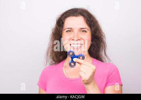 Jeune femme heureuse de jouer avec un spinner fidget Banque D'Images