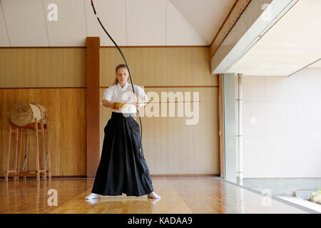 Caucasian woman practicing Kyudo traditionnel tir à l'arc japonais Banque D'Images