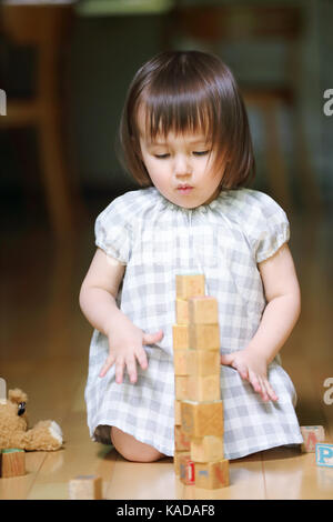 Jeune fille de race mixte avec des blocs en bois Banque D'Images