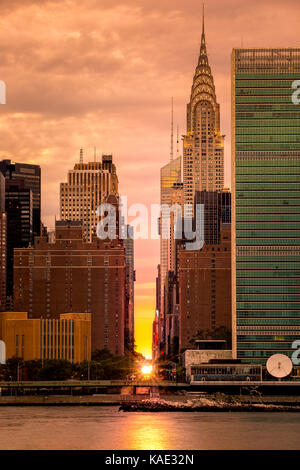 Manhattanhenge à New York, le long de la 42e rue, vue de Queens, à travers l'East River. manhattanhenge est un événement au cours de laquelle le soleil couchant est alig Banque D'Images