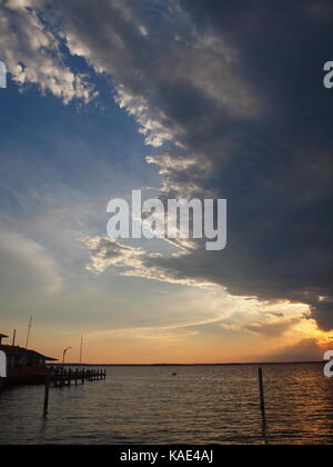 Coucher du soleil sur la baie de Barnegat, New Jersey, avec des nuages et des rayons de soleils dans la distance. Banque D'Images