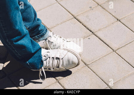 Les pieds des femmes dans les chaussures de sport sont sur le trottoir Banque D'Images