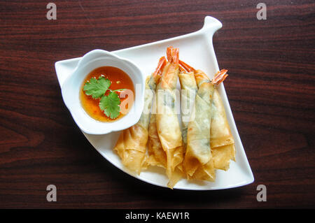 Rouleaux de Crevettes, crevettes entières roulé avec des feuilles de basilic dans un wrapper de riz croustillant, frit et servi avec notre sauce sauce aigre-douce maison. Banque D'Images