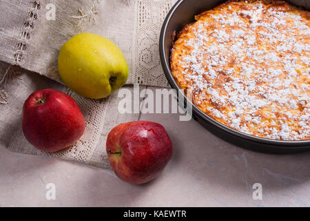 Du fait maison tarte aux pommes. dessert prêt à manger. Plusieurs des pommes rouges et vertes organiques dans l'arrière-plan. Banque D'Images