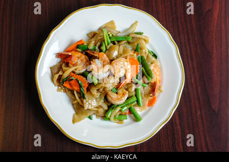 Khee pad mao, sautés avec des nouilles de riz larges, piments, carottes, haricots verts, oignons, tomates et feuilles de basilic doux. Banque D'Images