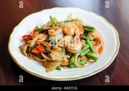 Khee pad mao, sautés avec des nouilles de riz larges, piments, carottes, haricots verts, oignons, tomates et feuilles de basilic doux. Banque D'Images