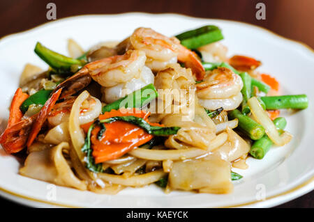 Khee pad mao, sautés avec des nouilles de riz larges, piments, carottes, haricots verts, oignons, tomates et feuilles de basilic doux. Banque D'Images