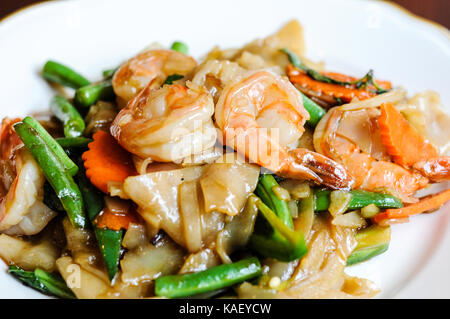 Khee pad mao, sautés avec des nouilles de riz larges, piments, carottes, haricots verts, oignons, tomates et feuilles de basilic doux. Banque D'Images