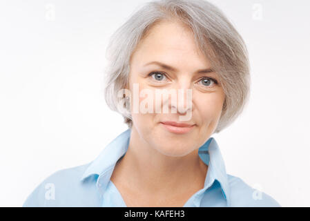 Charmante femme aux cheveux gris smiling at the camera Banque D'Images