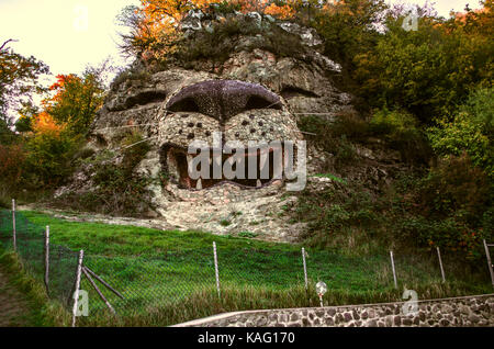 Tête de lion sculpture nature à rock au bord route en soirée d'automne Banque D'Images