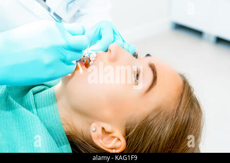 Femme dentiste vérifiant les dents du patient avec accolades au bureau. Clinique dentaire, médecine, dentisterie concept. Equipement dentaire. close up. Banque D'Images