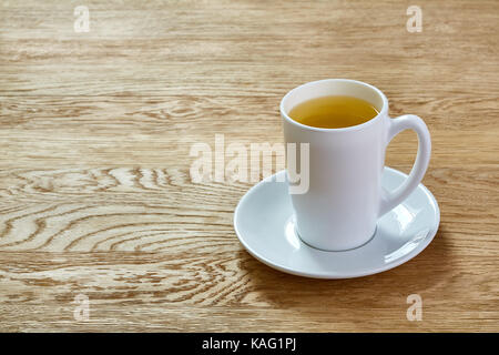 Tasse de thé à la menthe et les feuilles vertes sur table lumineuse Banque D'Images