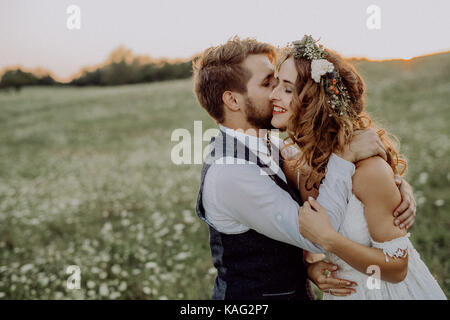 Belle mariée et le marié au coucher du soleil en pleine nature. Banque D'Images