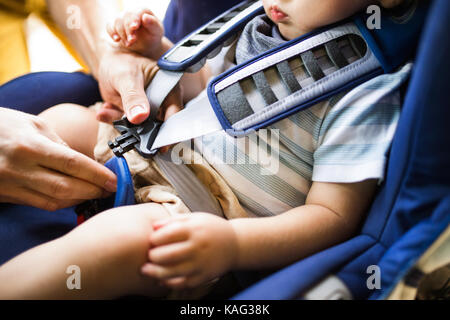 Ceinture de fixation père pour son fils dans la voiture. Banque D'Images