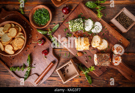 Vue de dessus de fromage doux avec des herbes et épices sur planche à découper en bois Banque D'Images