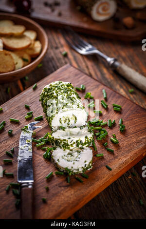 Le fromage avec la ciboulette sur planche à découper en bois Banque D'Images