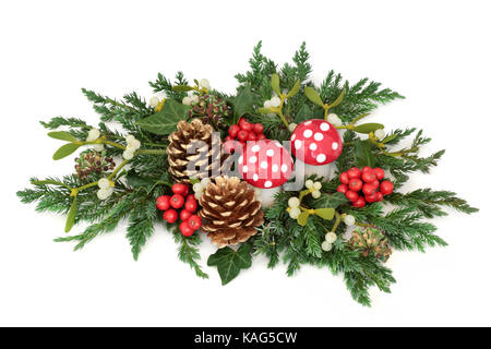 Décoration de Noël avec des ornements de champignons agaric fly, houx, pommes de pin, du gui, de cèdre et de cyprès et de genévrier branches feuilles lierre sur white Banque D'Images