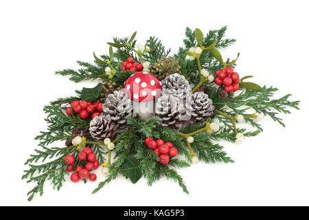 Fantasy de l'hiver et Noël décoration avec champignons agaric fly ornement, houx, lierre, de gui, de lierre, de feuilles de cèdre et de genévrier et de pin branches de cyprès Banque D'Images