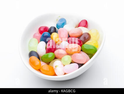 Jelly Beans sweet bonbons colorés dans un bol blanc sur fond blanc Banque D'Images