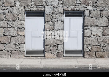 Deux portes de métal gris gris en mur de pierre. fond photo texture Banque D'Images