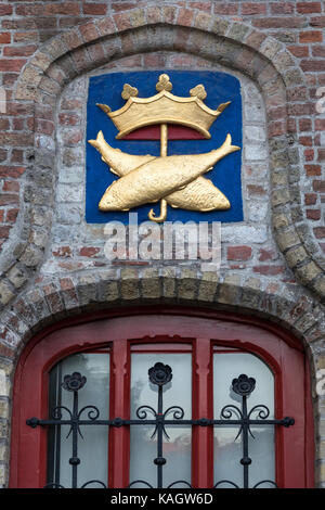 Symbole au-dessus d'une fenêtre à l'vismarkt (marché aux poissons) dans la ville historique de Bruges en Belgique. Le centre-ville historique est classé au patrimoine mondial de l'assis Banque D'Images