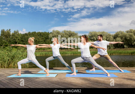 Groupe de personnes faisant des exercices de yoga en plein air Banque D'Images