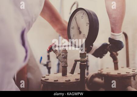 Plombier compteur de pression photo gros plan. caucasian worker contrôler sur la plomberie des soupapes. Banque D'Images