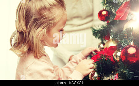 Little girl decorating Christmas Tree at home Banque D'Images