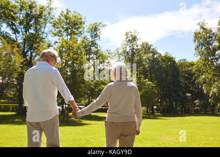 Happy senior couple walking at summer park Banque D'Images