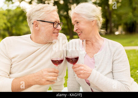 Happy senior couple drinking wine at summer park Banque D'Images